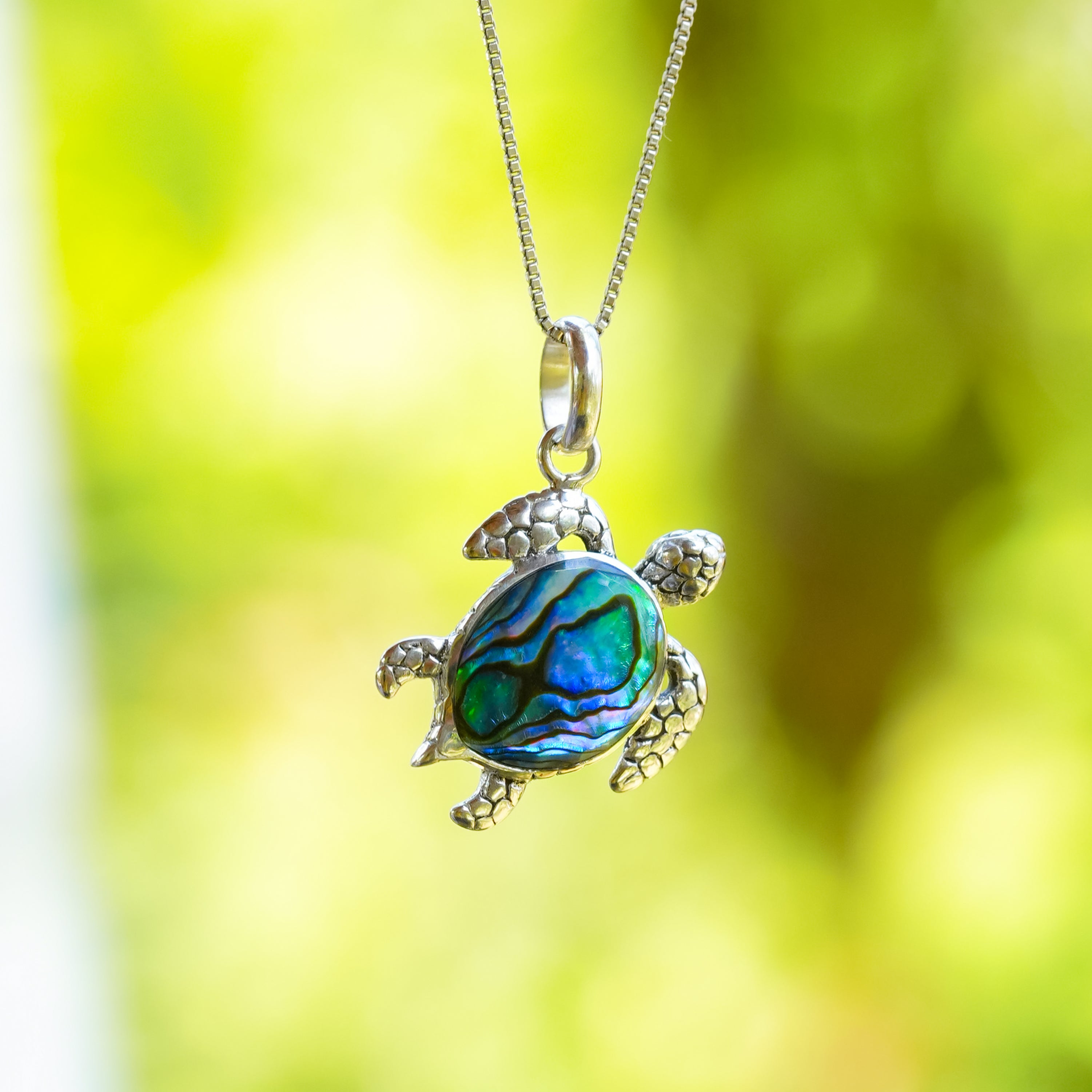 Front‑view image of the same turtle‑shaped pendant with abalone‑shell inlay, shown from a different angle.
