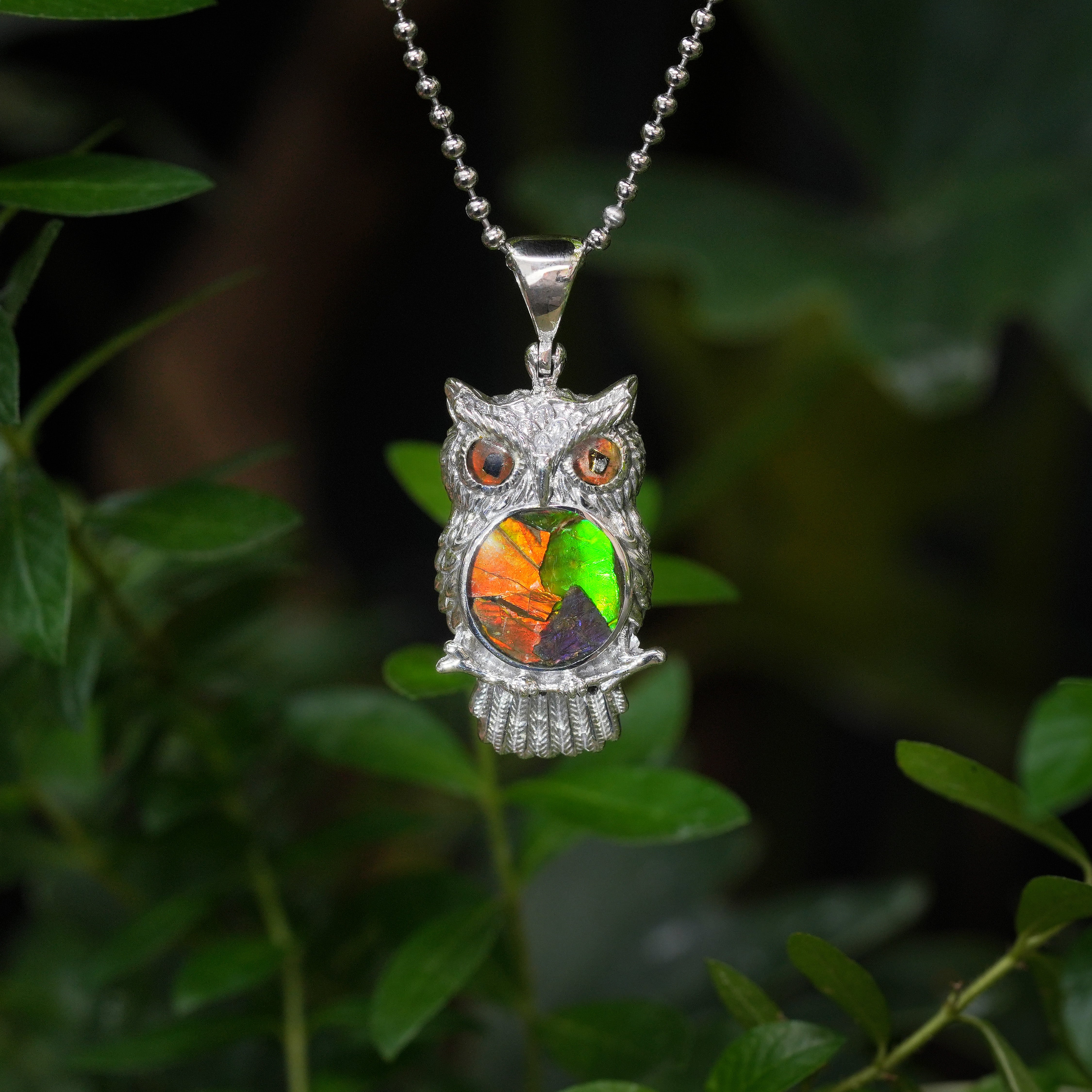 Front‑view of the owl pendant necklace with a multicolor ammolite inlay.