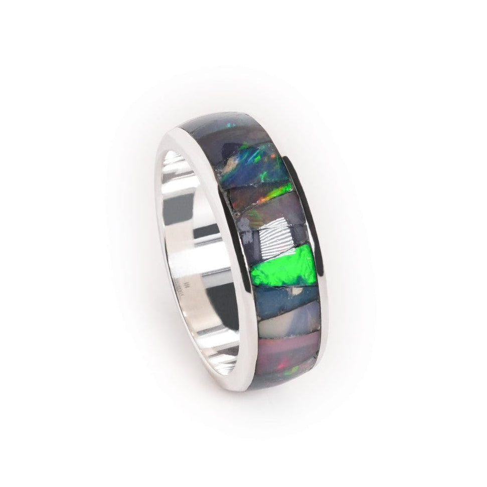 Angled view of a channel ring with Ethiopian opal inlay showing green, blue, and pink play‑of‑color