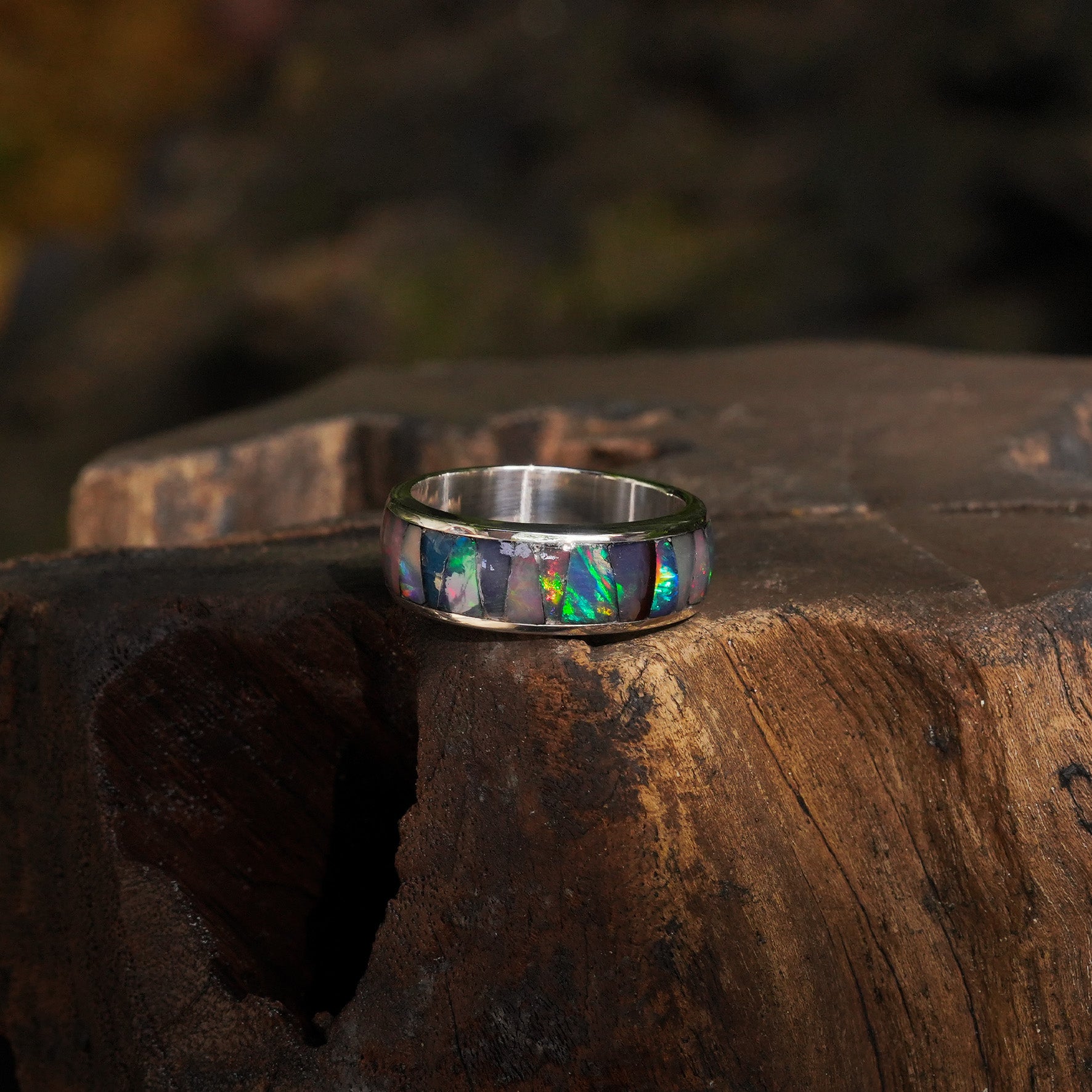 Third alternate front view of a channel ring with Ethiopian opal inlay showing green, blue, and pink play‑of‑color