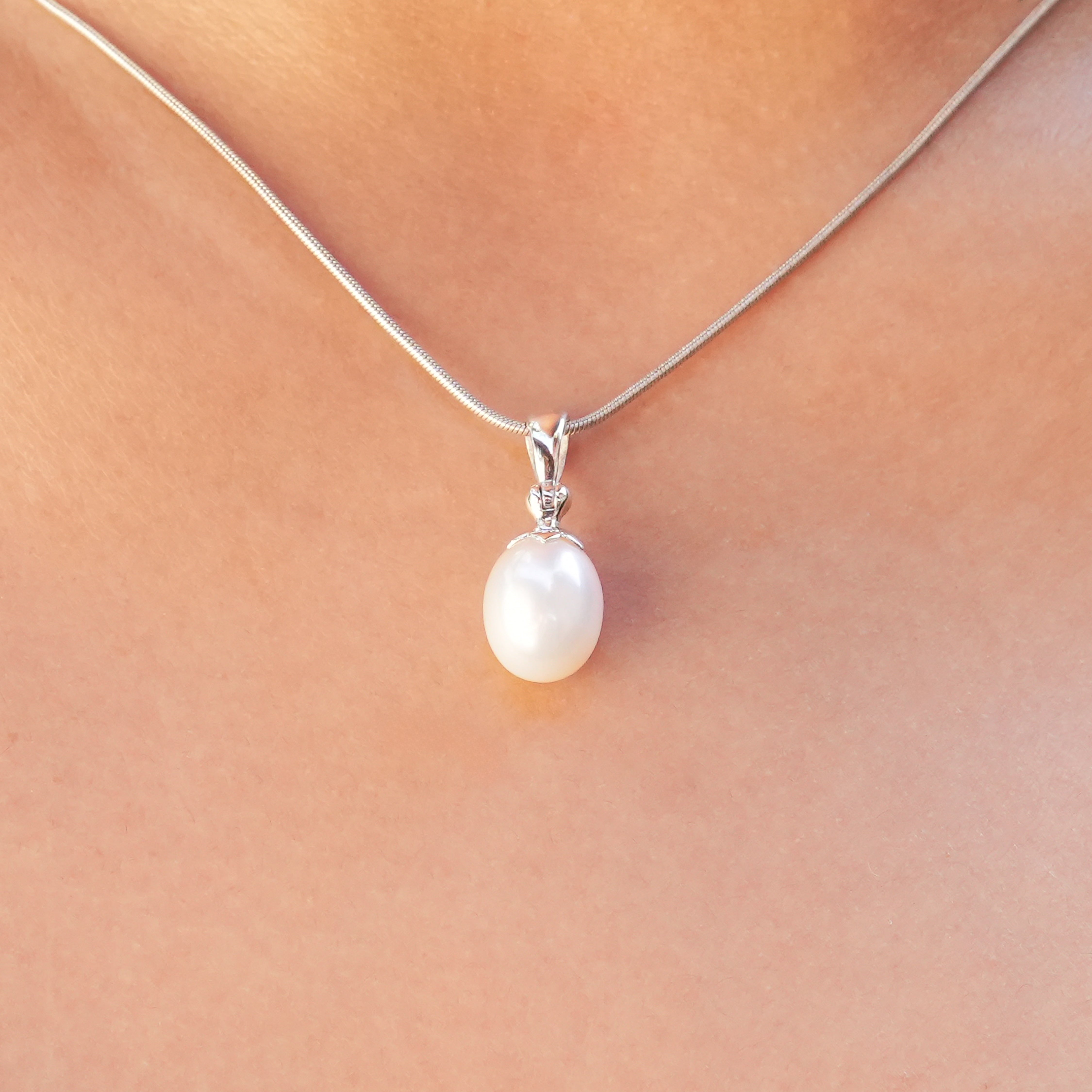 Freshwater pearl pendant necklace worn on a neckline, showing the oval pearl drop size reference.