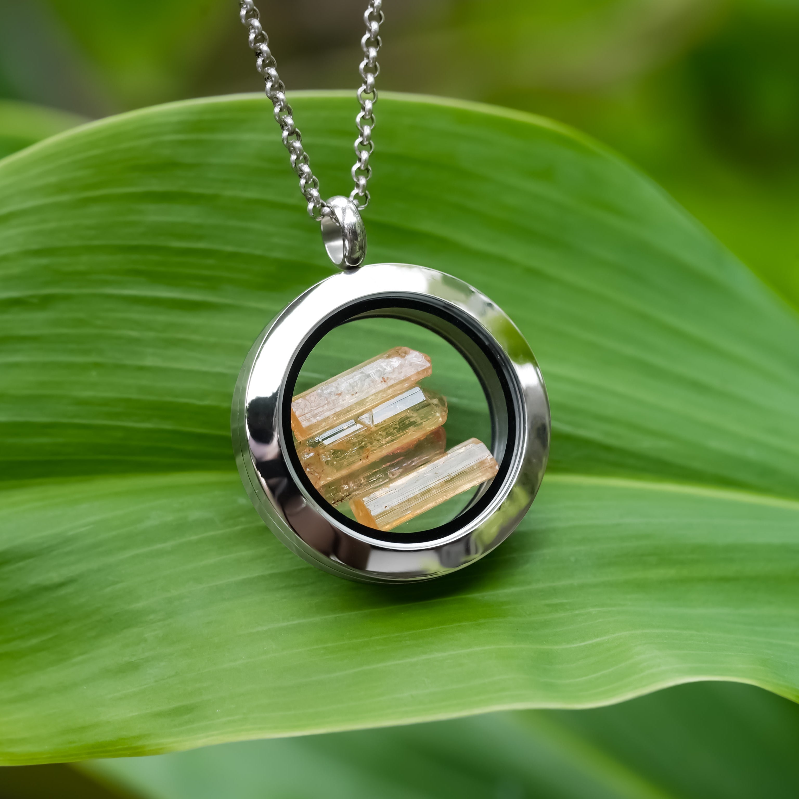 Front-view image of the same necklace shown hanging to highlight the circular frame and suspended crystal pieces.