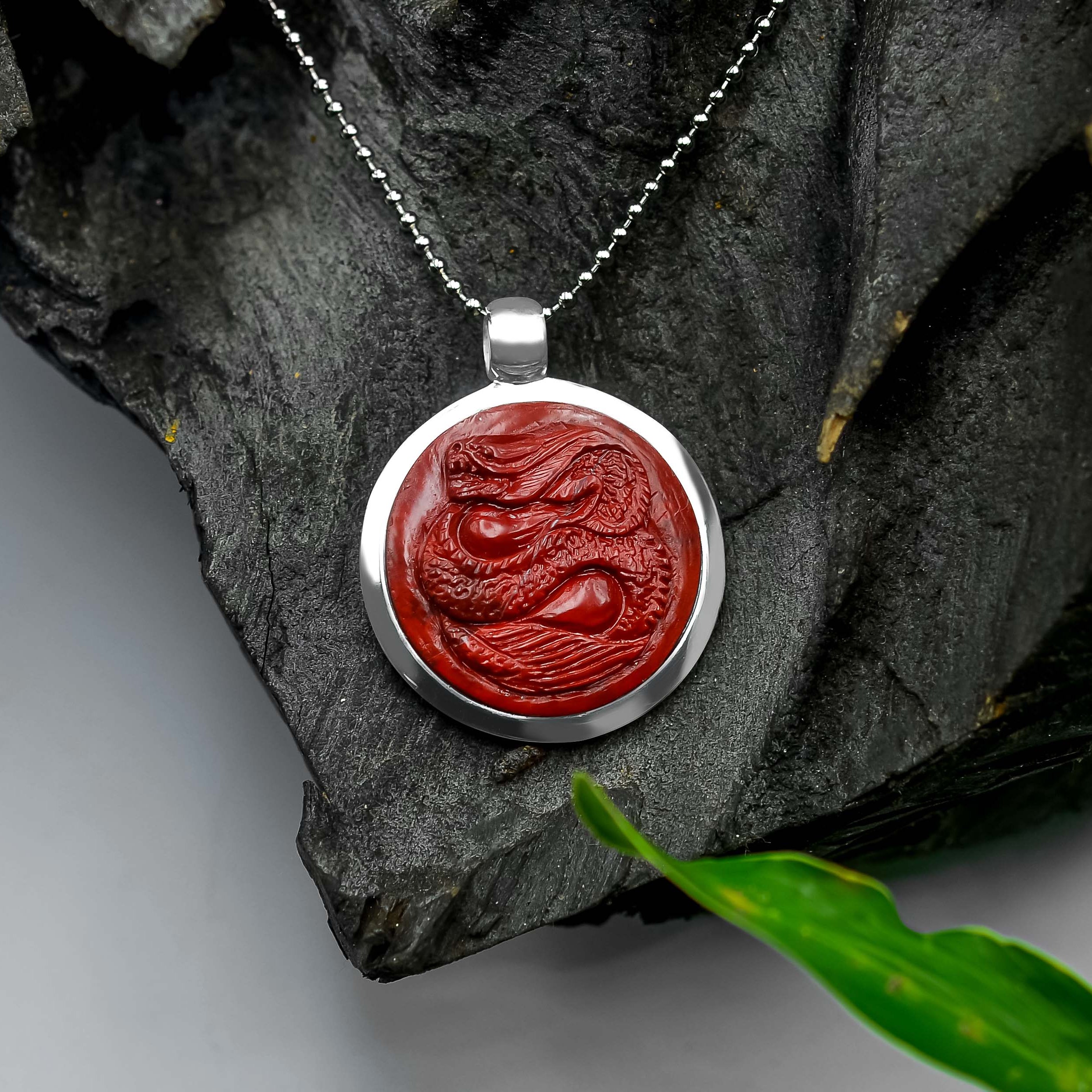Front-facing view of the same jasper dragon medallion pendant worn on a chain, showing the carved dragon design centered within the circular stone.