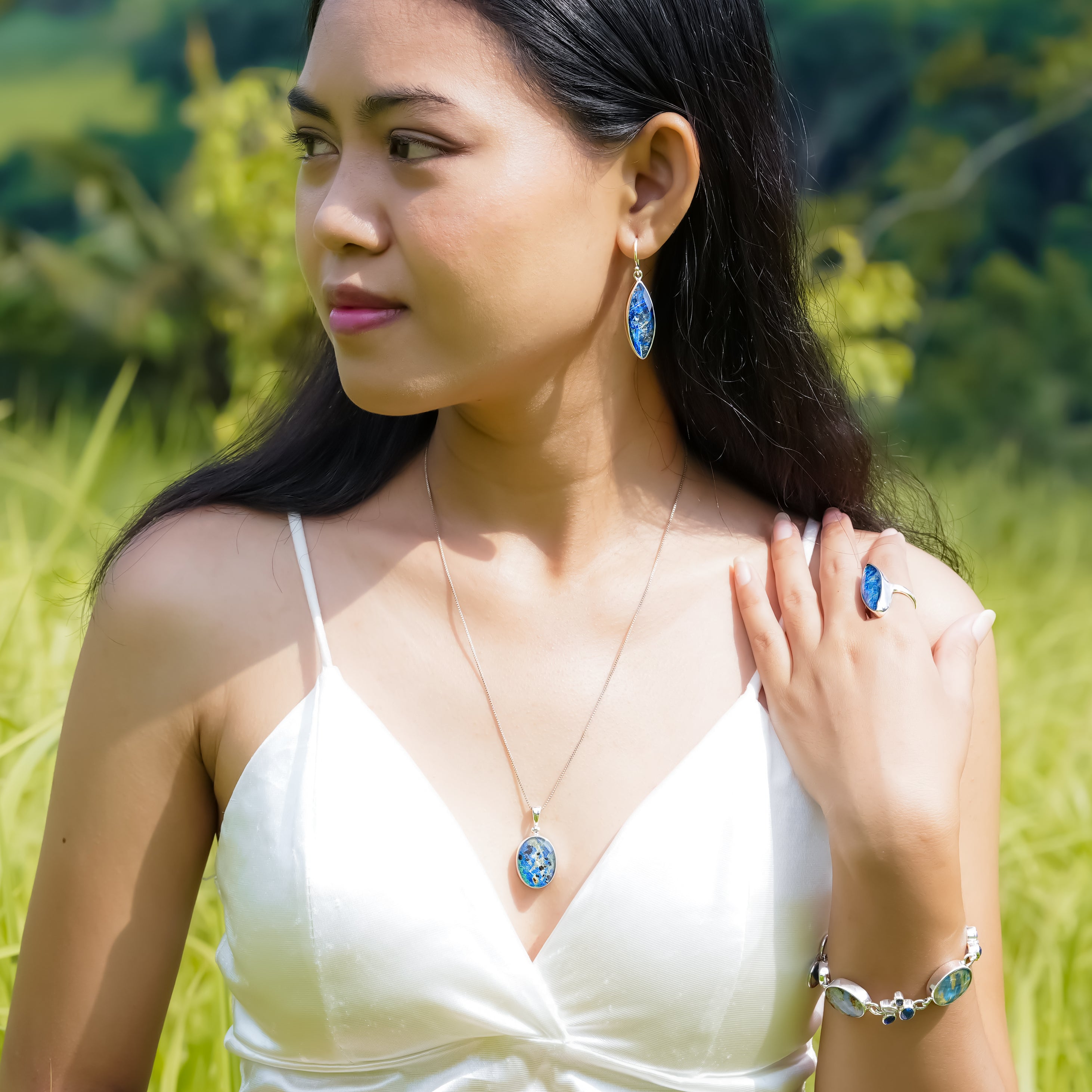 Faceted azurite malachite oval pendant worn on a neckline to demonstrate scale