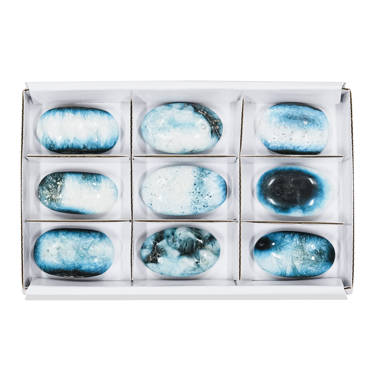Second front‑view image of polished oval Blue Ice Glacierite palm stones arranged in a sturdy flat box with sections, showing blue and dark blue patterning on each stone surface. Showcasing variations.