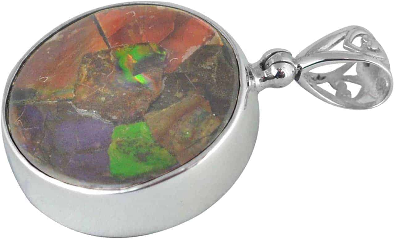 Front‑view angled image of a round pendant featuring multicolored Ammolite set in a polished silver frame with a filigree bail, showing the stone pattern and the thickness of the silver bezel.