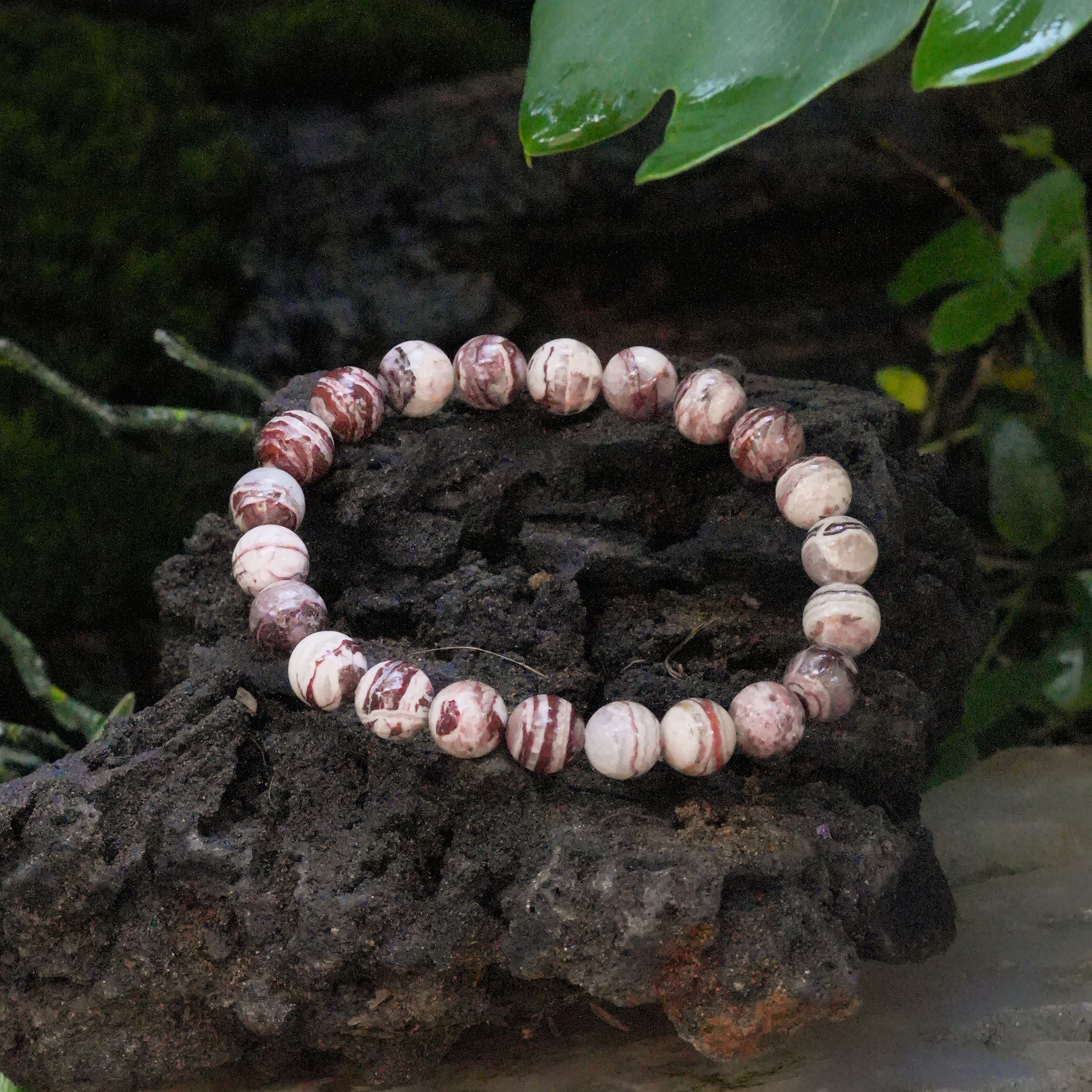 Angled view of an Arizona Agate Mountain bead bracelet showing variations in color and patterns.