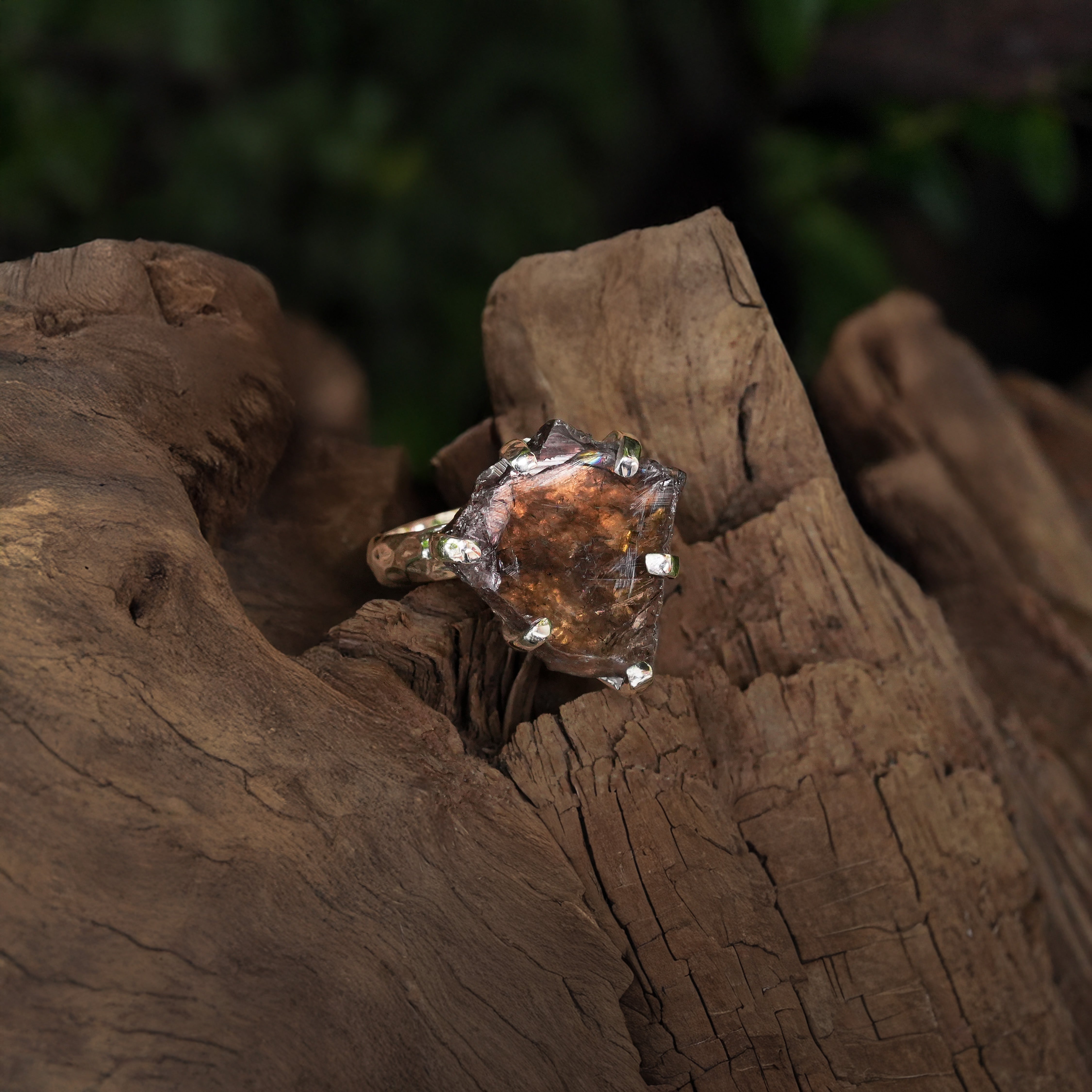 Second alternate angled view of an Axinite prong‑set ring showing grey-brown crystal 