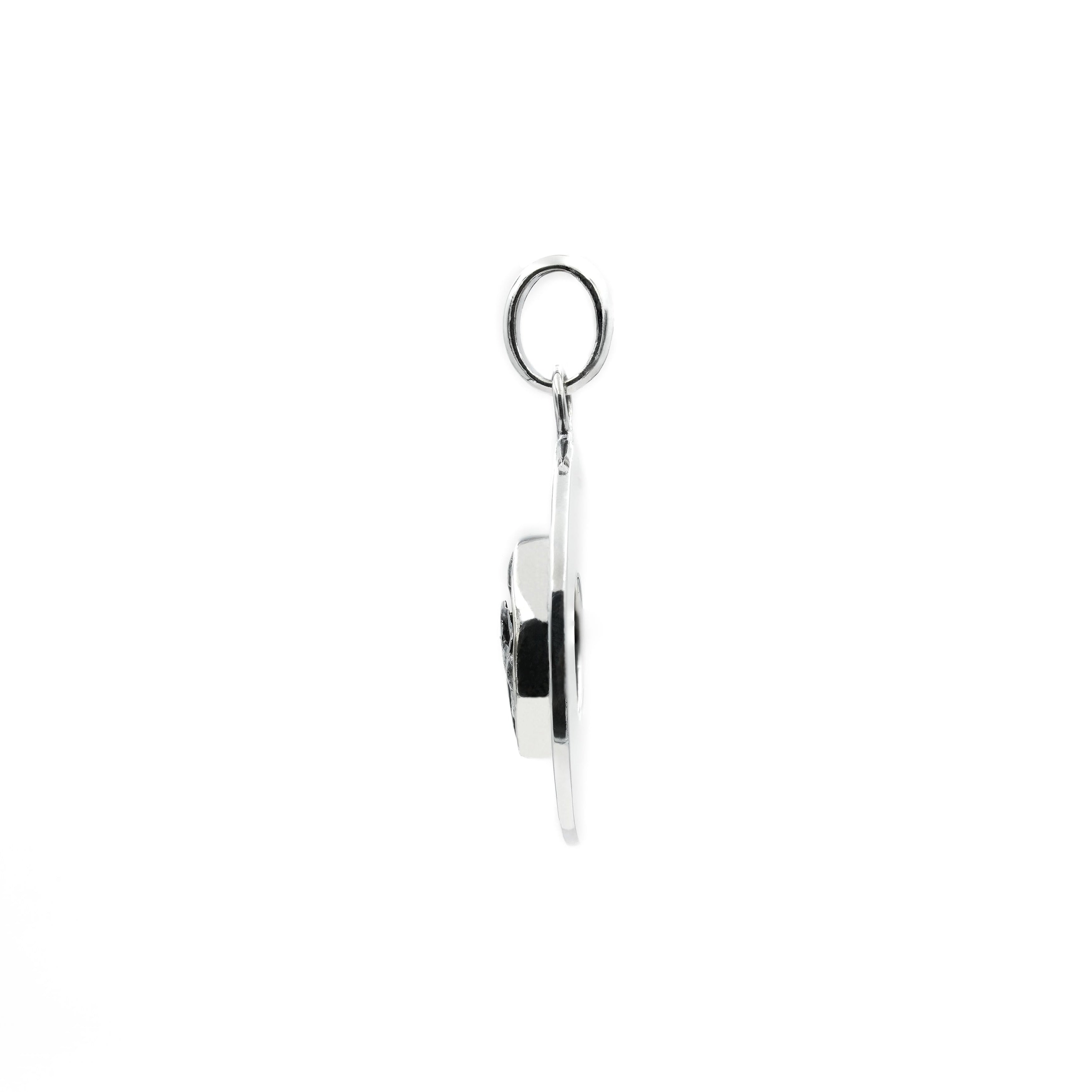 Side view of a sterling silver pendant showing the thickness of the setting and the loop bail.