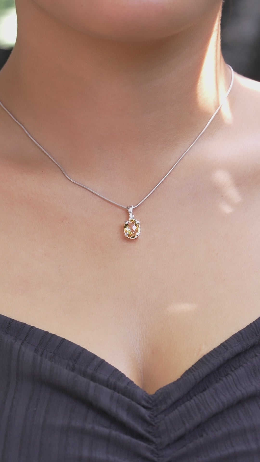 Video showing the oval faceted citrine pendant in sterling silver worn on a chain, demonstrating movement and appearance when worn.
