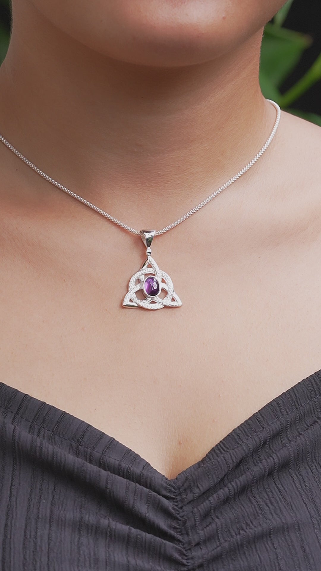 Video showing an amethyst triquetra pendant necklace worn on a model outline for size reference. 