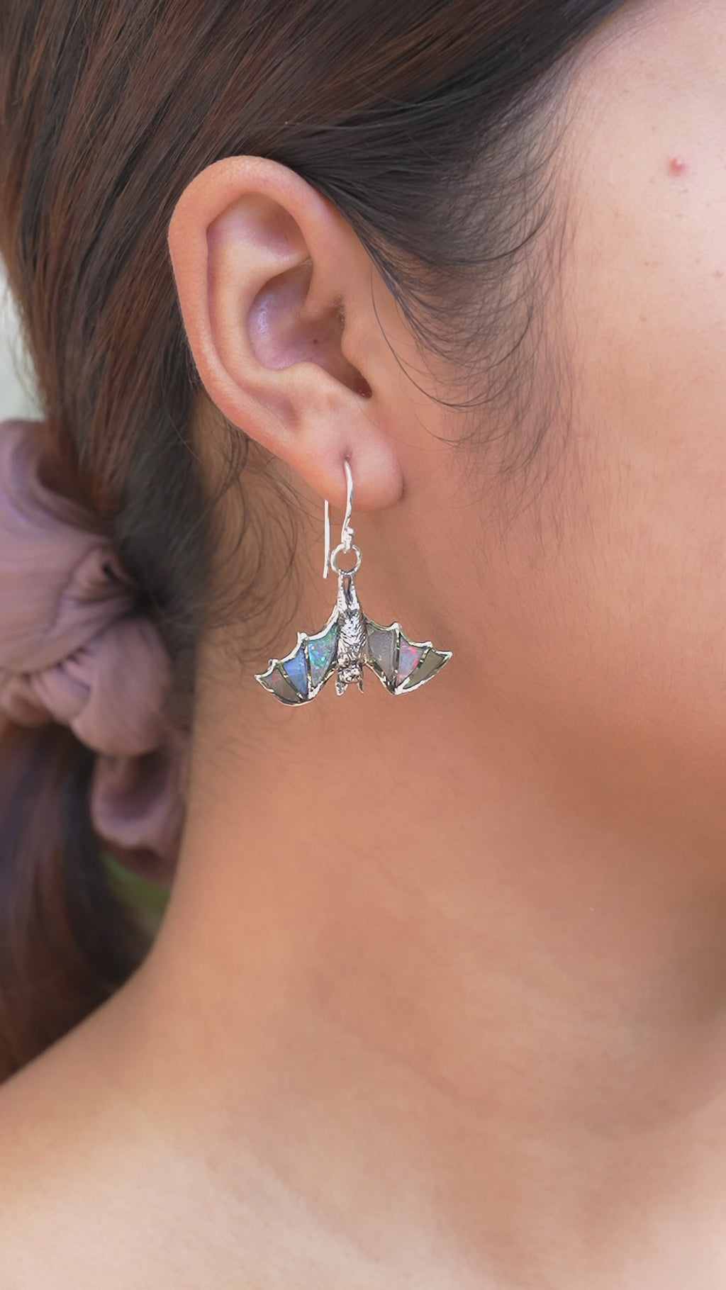 Video showing Ethiopian Opal hanging bat earring worn on ear for size reference