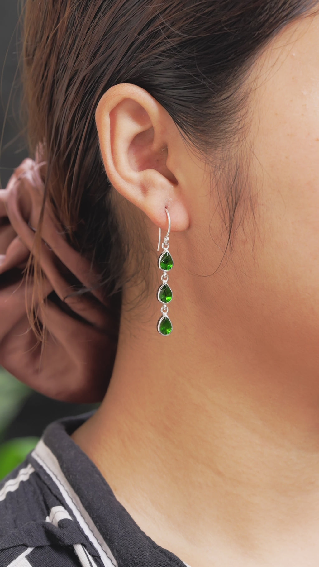 Video showing the chrome diopside 3‑stone drop earrings worn on the ear, demonstrating length, movement, and how the earrings hang when worn.