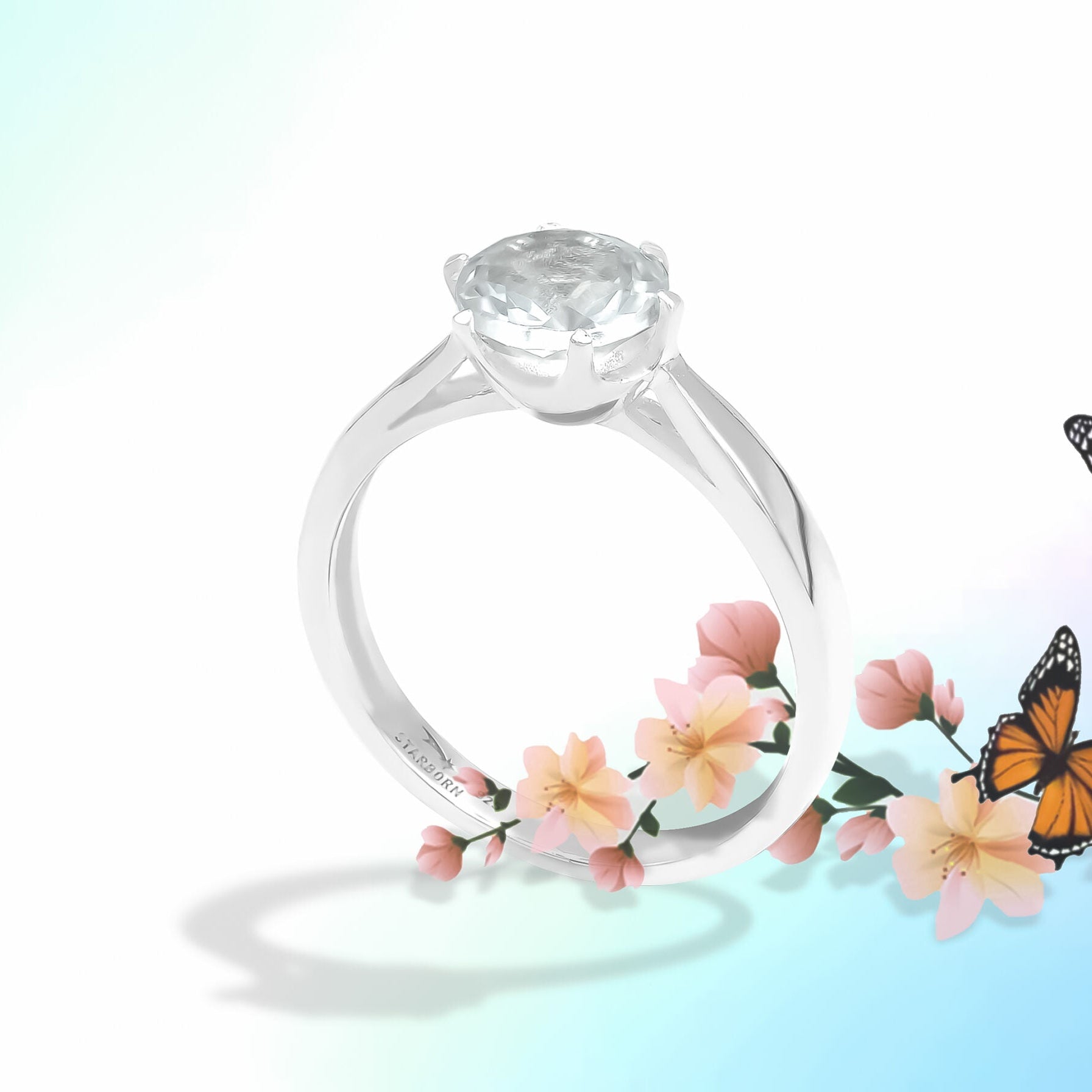 Angled front view of the same faceted danburite ring, showing the gemstone from a slight tilt with the prong setting and band curvature visible.